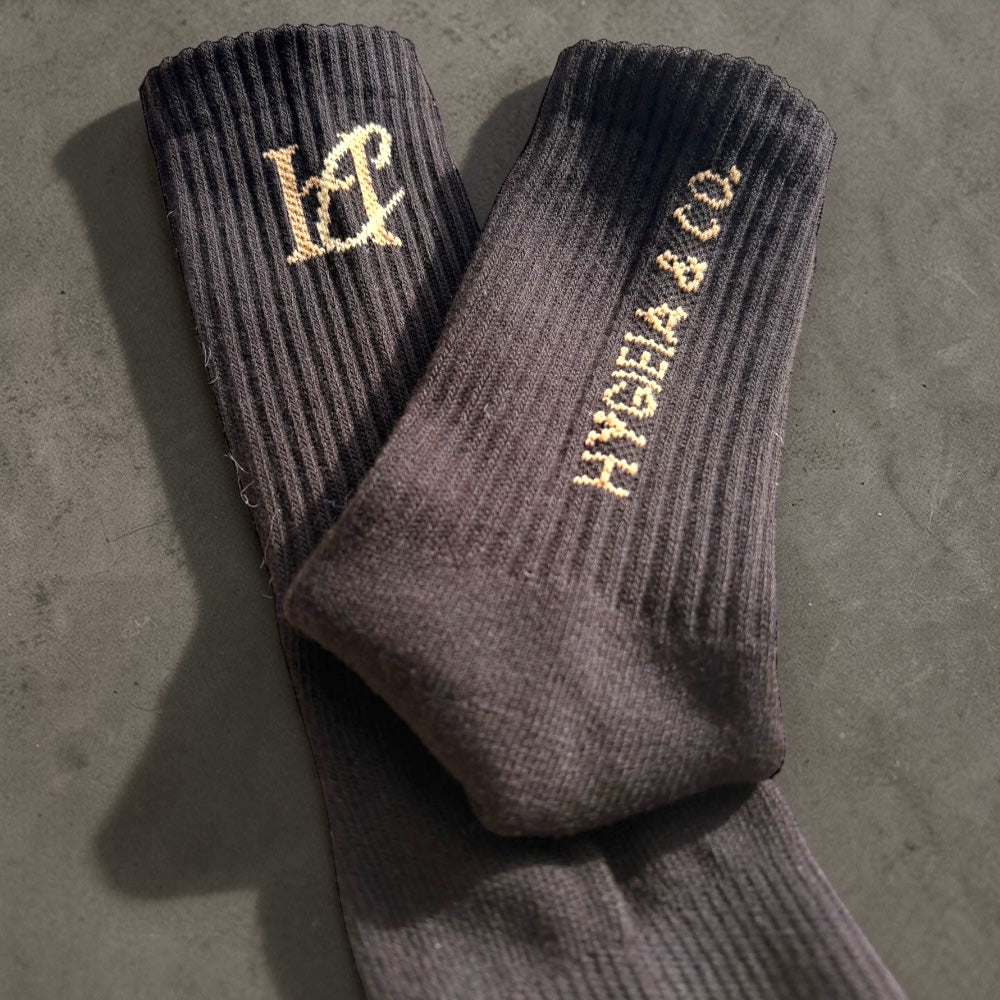 Black custom crew socks with a gold Jacquard-knitted logo